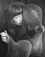 Ruth Asawa holding a form-within-form sculpture, 1952.